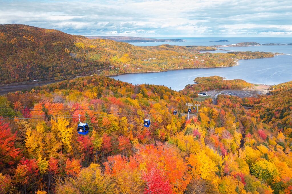 The Cape Smokey gondola over Cape Breton hills in full autumn colour, with St Anns Bay beyond